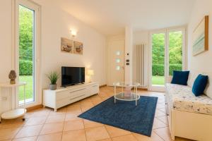 a living room with a couch and a tv at Villa Seashell in Lignano Sabbiadoro