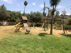 a playground with a slide in a yard at Apartment Galia Mohammedia in Mohammedia