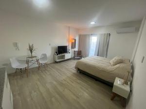 a bedroom with a bed and a table and a television at L&M Suite Monoambiente in Belén de Escobar