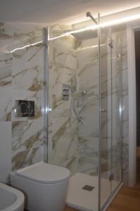 a bathroom with a toilet and a glass shower at Palazzo del Principe in Castel di Sangro +33 photos