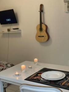 Una mesa con un plato y una guitarra en una pared. en Great apartment avec stationnement, en Saint-Étienne 1 foto más