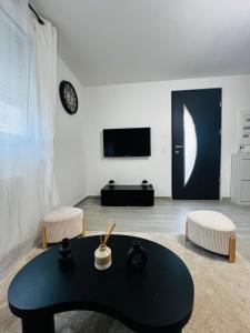 a living room with a black table and a tv at Appartement cosy prêt de Paris Cdg, Astérix , Parc des expositions et Centre de formation CAMAS in Tremblay-En-France