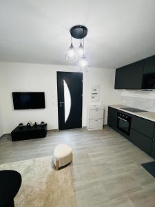 a kitchen with black and white cabinets and a table at Appartement cosy prêt de Paris Cdg, Astérix , Parc des expositions et Centre de formation CAMAS in Tremblay-En-France +2 photos