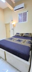 a bedroom with a bed with a blue comforter at Quick home in Al Ain