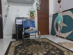 a blue chair sitting in a room with a rug at Casa rua 09 de janeiro 13 in Benevides