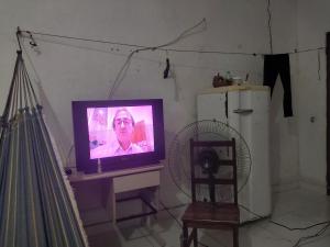 a television sitting on a table with a fan at Casa rua 09 de janeiro 13 in Benevides