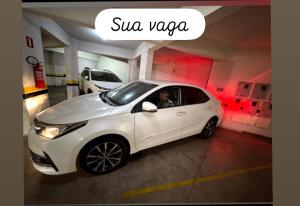 a white car parked in a parking lot at Apartamento super central até 9 pessoas in Divinópolis