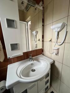 パリチにあるNiki Apartmentの白い洗面台と鏡のあるバスルーム +6枚の写真