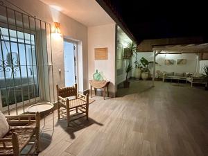 Zimmer mit Stühlen, Tischen und einem großen Fenster in der Unterkunft La Brisca Sun & Soul Más que un lugar una forma de vivir Málaga in Málaga