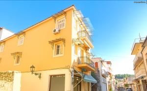a yellow building with a fire escape on a street at Nafpaktos happy town Apartment in port in Nafpaktos
