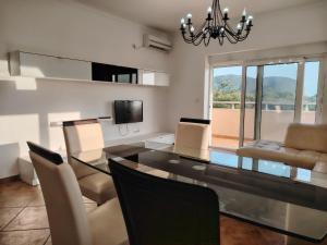 a dining room with a glass table and chairs at Simple Stay in Buljarica