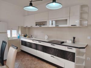 a kitchen with white cabinets and a counter top at Simple Stay in Buljarica