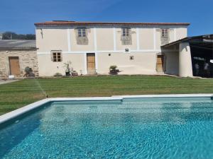 a large swimming pool in front of a house at Finca As Roeles Caión in Cayón
