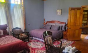 a bedroom with two beds and a table and chairs at The Journey GuestHouse in Ladybrand