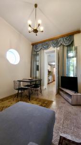 a living room with a table and a couch at Doni's Charming Vintage Home in Tirana +19 photos