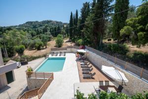 Blick auf einen Pool mit Stühlen und einem Haus in der Unterkunft Melina Suite Corfu in Kanálion