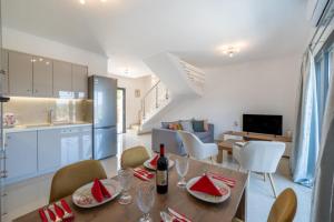 eine Küche und ein Wohnzimmer mit Tisch und Stühlen in der Unterkunft Melina Suite Corfu in Kanálion