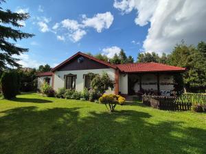 a small house with a green yard with a fence at Tarnów Zawada Apartament in Tarnów