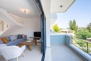 Zimmer mit Sofa, Tisch und Balkon in der Unterkunft Melina Suite Corfu in Kanálion