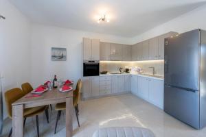 eine Küche mit Holztisch und Kühlschrank in der Unterkunft Melina Suite Corfu in Kanálion