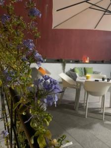 Habitación con mesa, sillas y flores púrpuras. en Apa Sicula, en Avola