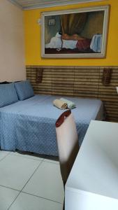 a room with two beds and a table and a mirror at Cantinho do Pequeno Arthur in Lençóis