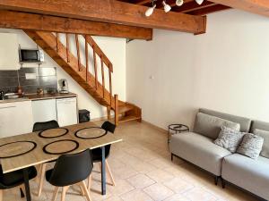 a living room with a table and a couch at Canalentin - proche Canal du Midi in Castelnaudary +1 photo