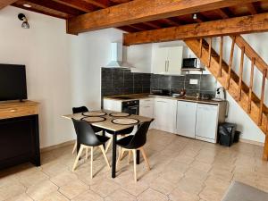 a kitchen with a table and chairs in a room at Canalentin - proche Canal du Midi in Castelnaudary