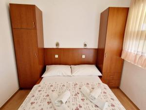 a bedroom with a bed with two pairs of slippers at Apartments Kosec in Vrsi +14 photos