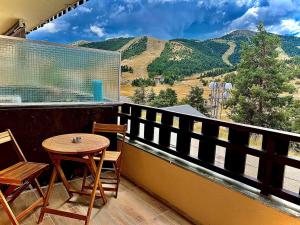 a balcony with a table and chairs and mountains at White dream in Gréolières les Neiges