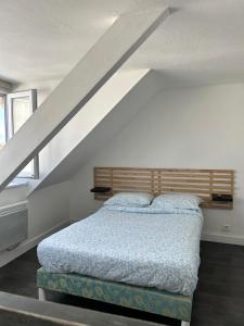 a bedroom with a bed under a stair case at Apartment La Fontaine in Carhaix-Plouguer