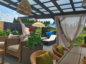a patio with chairs and a table and an umbrella at Apartament Lipowa 2 in Mrągowo