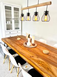 a dining room table with chairs and lights at Wohnen auf dem Ponyhof in Laer