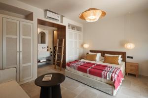 a bedroom with a bed and a couch and a table at Phoenicia Nature Naxos in Kastraki