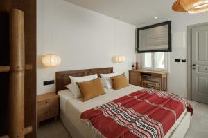 a bedroom with a bed with a red blanket on it at Phoenicia Nature Naxos in Kastraki Naxou
