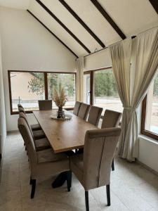 a dining room with a wooden table and chairs at Vikendica WoodAvenue Blidinje in Blidinje