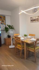 - une salle à manger avec une table, des chaises et un ventilateur dans l'établissement Pine Suites Tagaytay Luxury Spacious 2 Bedroom Condo With Balcony Amenities View, à Tagaytay