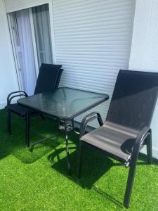 two chairs and a glass table and a table and chairs at Moj dom Petrićevac in Banja Luka