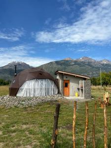 a small house with a tent in a field at Nomade Patagonia Glamping & Domos in Trevelin