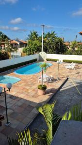 a pool with chairs and a table and a umbrella at Hospede-se bem em Salinas in Salinópolis