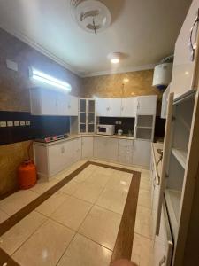 a kitchen with white cabinets and a blue wall at وحدات طيبة in Medina
