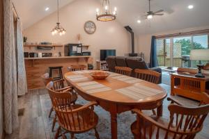 Il dispose d'une cuisine et d'un salon avec une table et des chaises en bois. dans l'établissement Amazing View Hot Tub Firepit BBQ Private Pets, à Rileyville