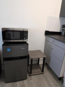 a microwave and a stool in a kitchen at Welcome Heart and Reliable Heart Vacation Houses in Miami