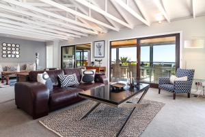 Una sala de estar con un sofá de cuero y una mesa. en Sweet Greta - Ocean Apartment With Sauna & Solar, en Ciudad del Cabo