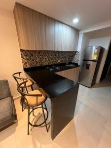 a kitchen with a black counter and a refrigerator at Manglar - Ciudad Mallorquin in Puerto Colombia +16 photos