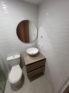 a bathroom with a toilet and a sink and a mirror at Manglar - Ciudad Mallorquin in Puerto Colombia