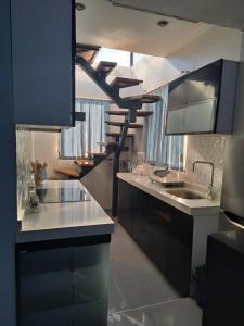 a kitchen with black cabinets and white counter tops at Cozy & Modern apartment in Arequipa!! in Arequipa