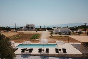 a swimming pool with lounge chairs and umbrellas at Phoenicia Nature Naxos in Kastraki