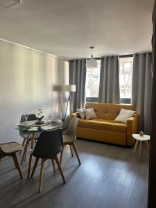 Una sala de estar con un sofá amarillo y una mesa. en DEPARTAMENTO MODERNO Y COMODO CERCA A MOVISTAR ARENA Y FANTASILANDIA, en Santiago