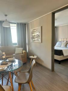 Una sala de estar con una mesa y una cama. en DEPARTAMENTO MODERNO Y COMODO CERCA A MOVISTAR ARENA Y FANTASILANDIA, en Santiago